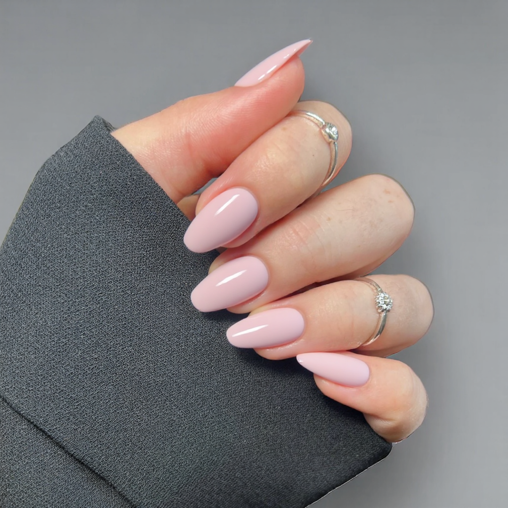 Short almond nails in a light pink, finished with a glossy topcoat for a soft, feminine vibe.