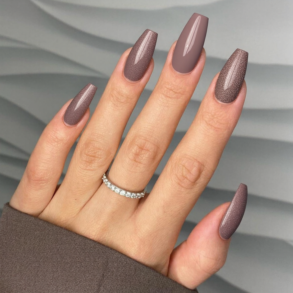 Long almond nails in a dusty mauve, with one accent nail in a matching glitter for texture.