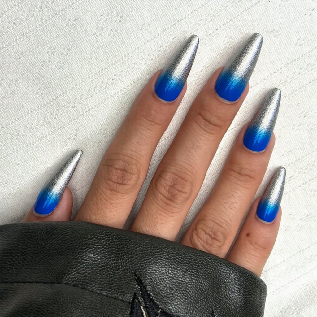 Long stiletto nails featuring a two-tone ombre from metallic silver to vibrant blue, capturing the essence of 2025 trends.