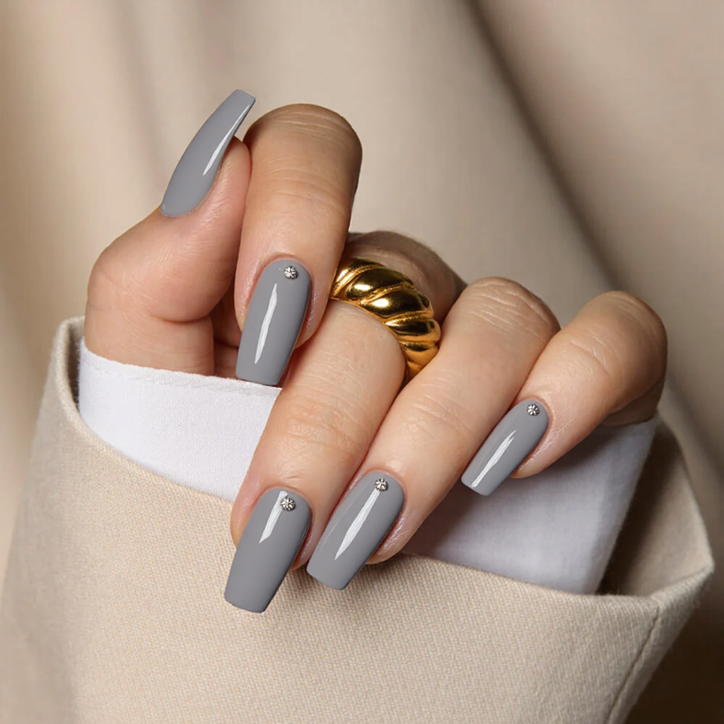Medium square nails in a soft gray, each with a tiny rhinestone for a subtle sparkle.