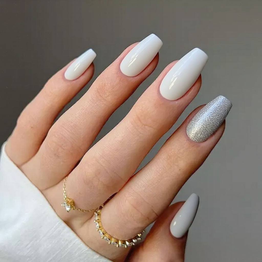 Medium stiletto nails in glossy white with a diagonal silver glitter stripe on one accent nail.