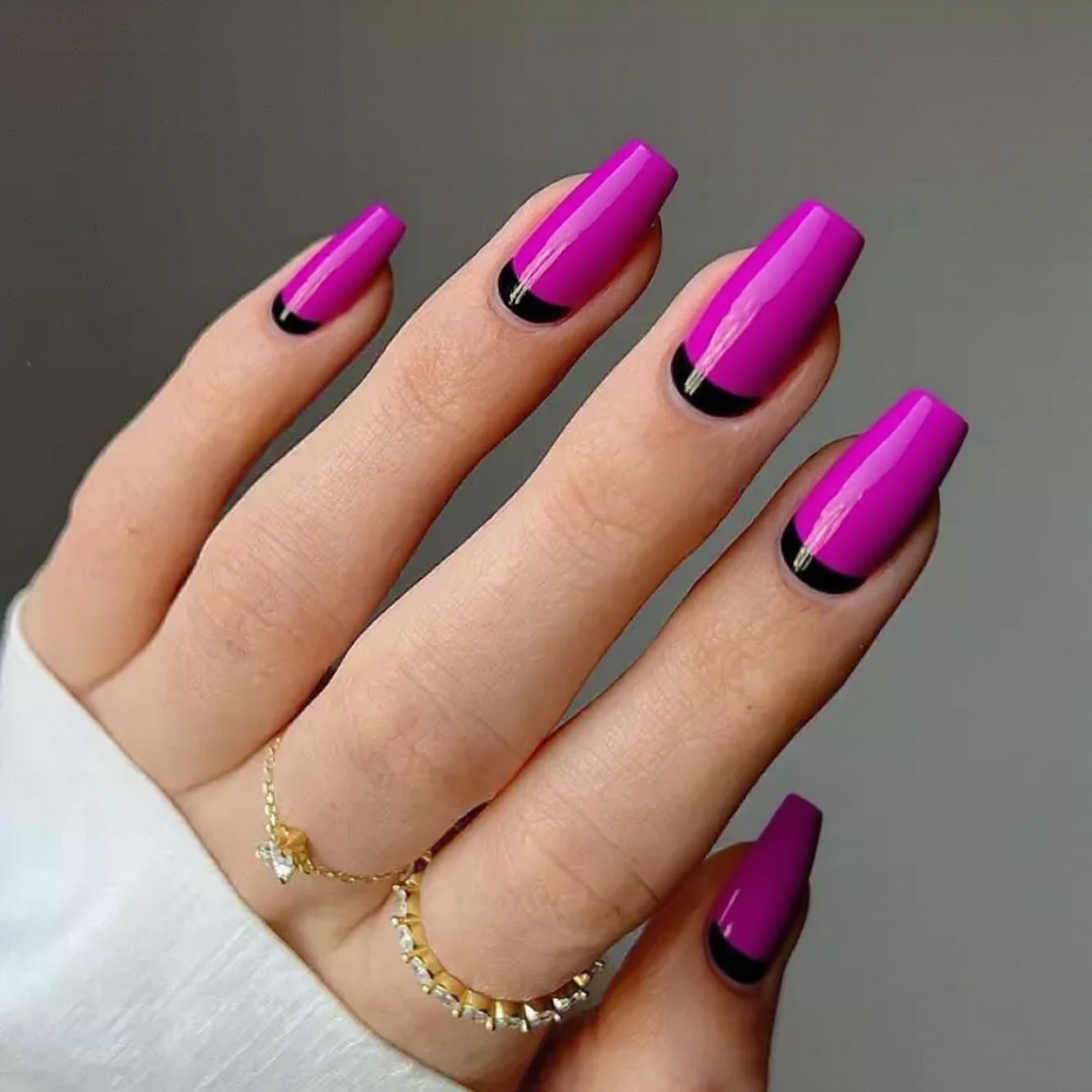 Medium stiletto nails in a vibrant fuchsia with black tips for a bold and striking February style.