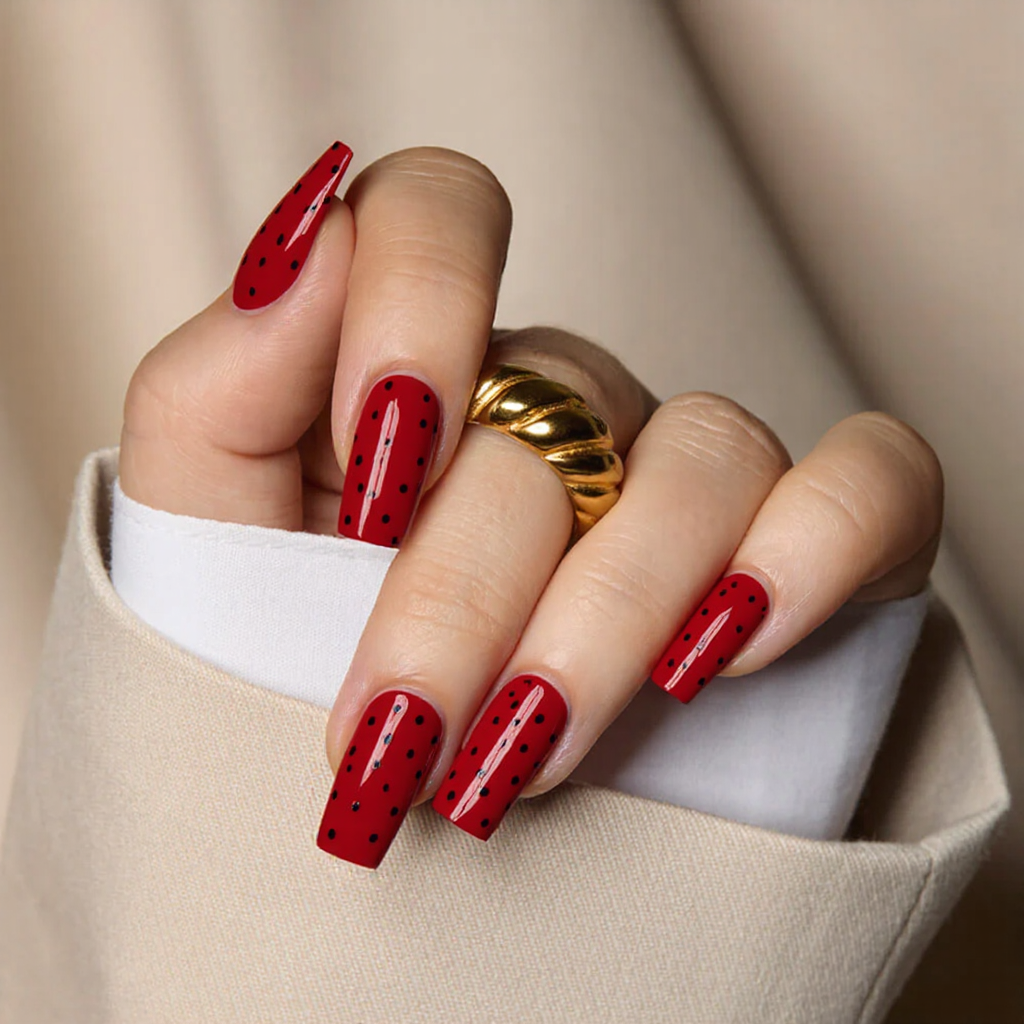 Medium square nails in a vibrant scarlet color, maybe add some subtle black dots for a fun accent.