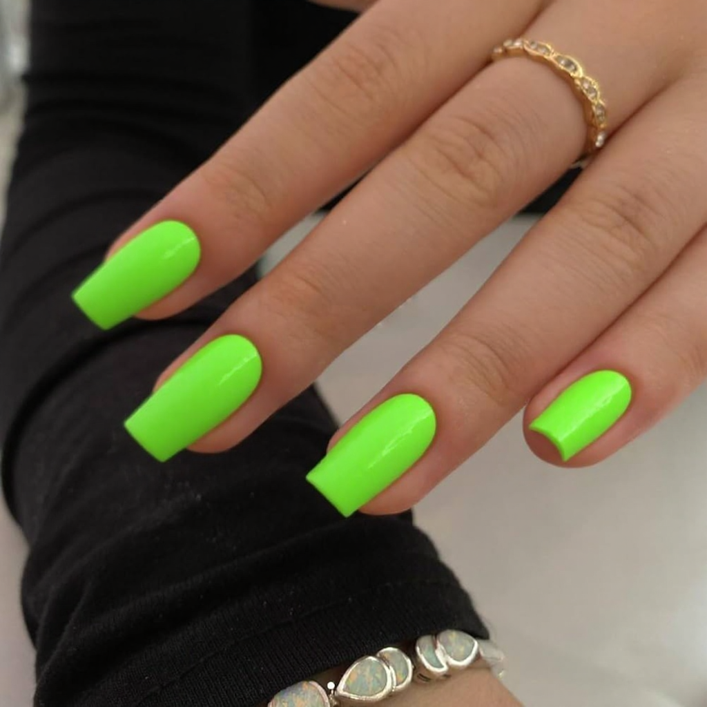Short stiletto nails in a vibrant neon green with a glossy topcoat, reflecting 2025's bold color preferences.