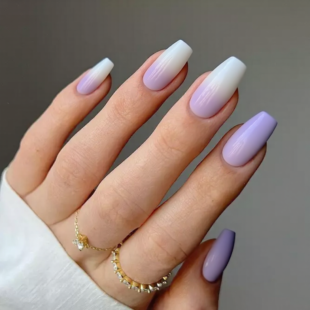 Medium stiletto nails in an ombre from white at the cuticle to lavender at the tip for a dreamy look.