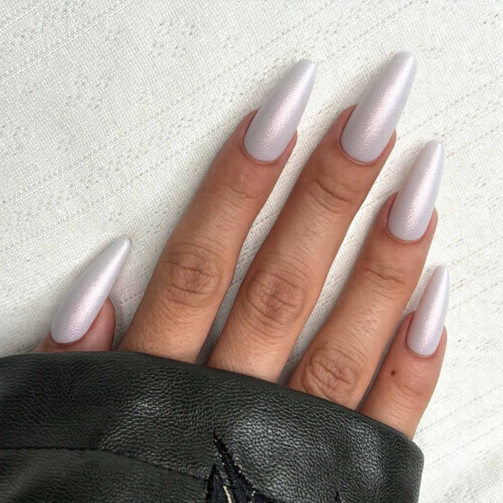 Long stiletto nails in a pearlescent white with subtle pink shimmer, perfect for a classy February event.