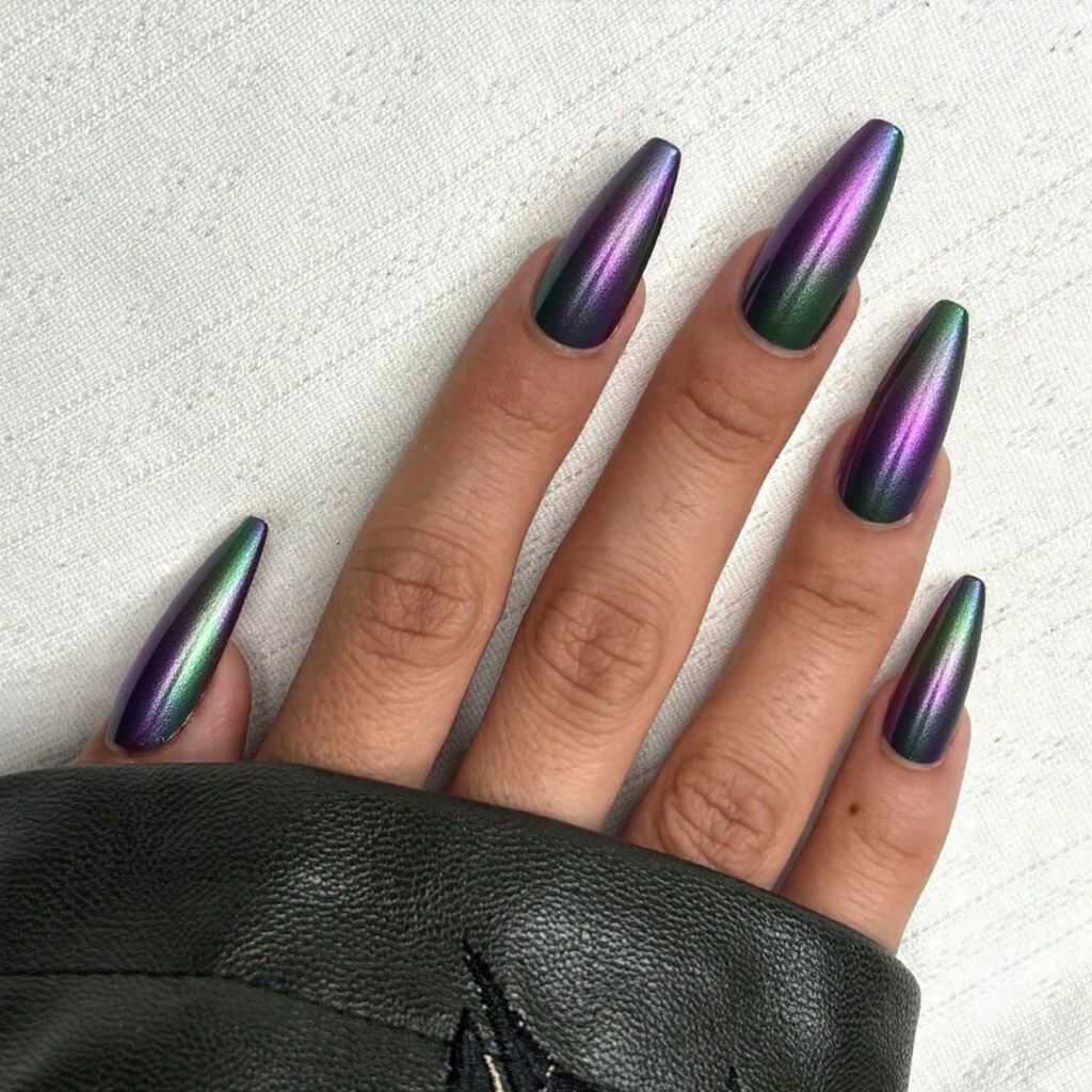 Long stiletto nails in a color-shifting chrome, moving from purple to green under different lights.