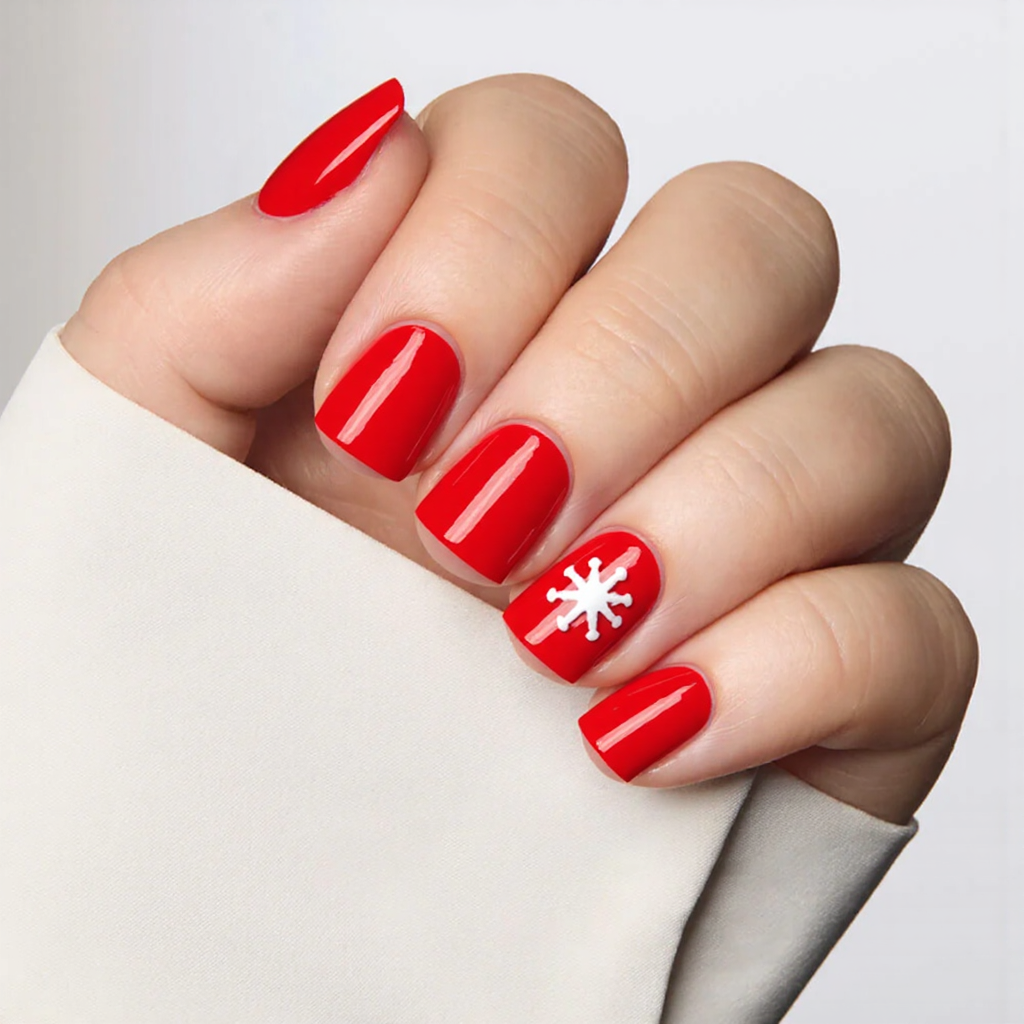 Let's do short square nails in a bright red with a single white snowflake on the middle nail for a festive pop.