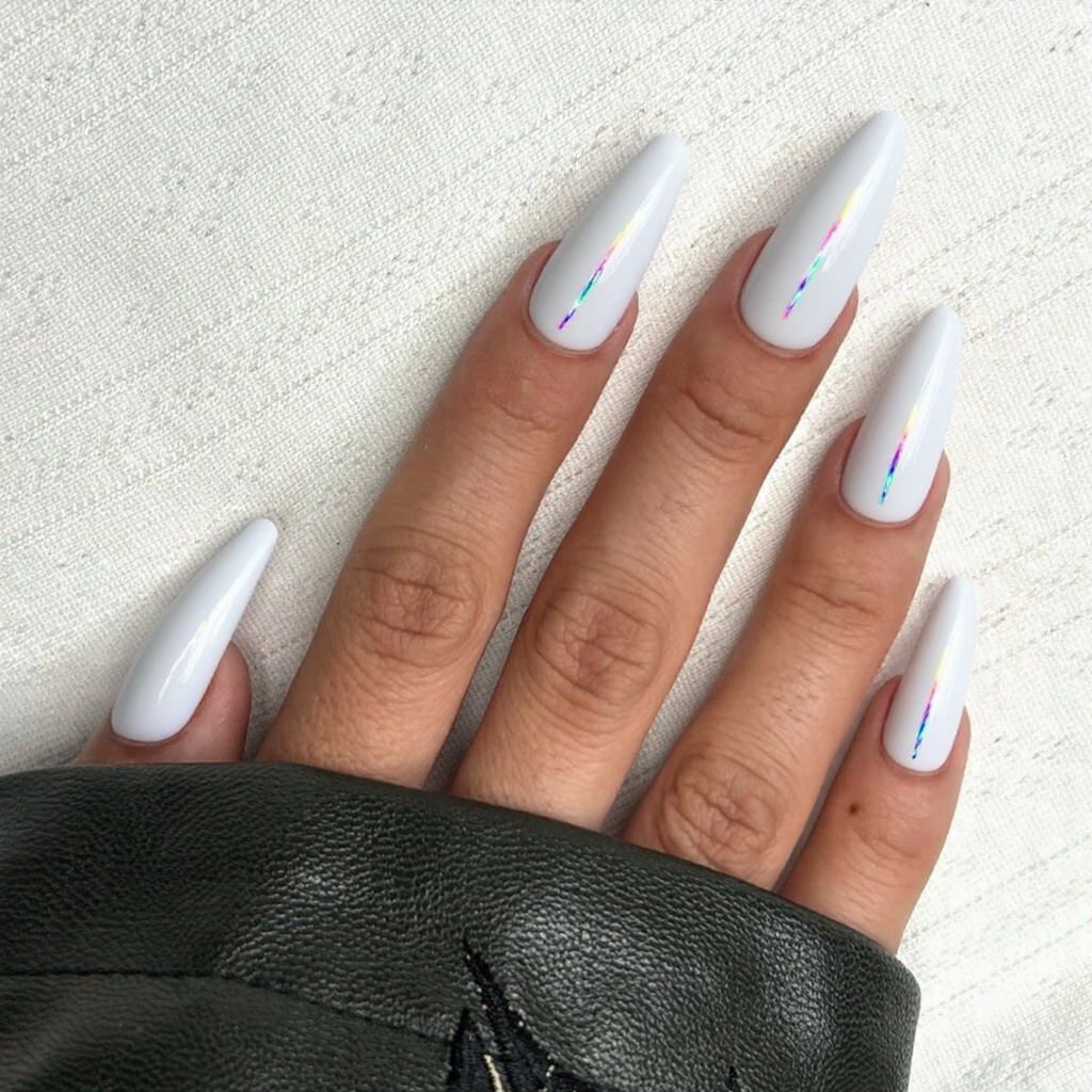 Long stiletto nails in glossy white, each with a thin rainbow holographic strip near the cuticle.