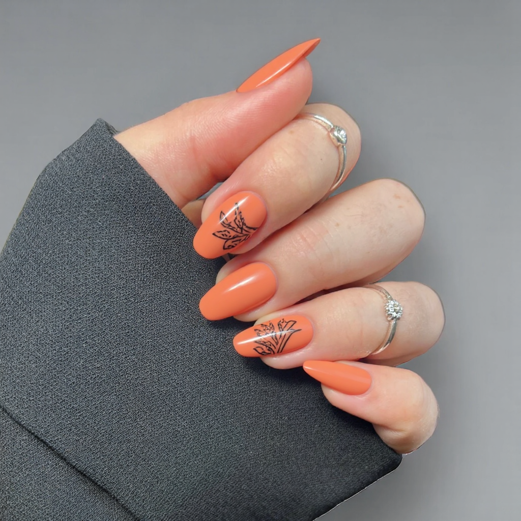 I'd love short almond nails in a soft terracotta hue with a negative-space leaf on one accent nail.