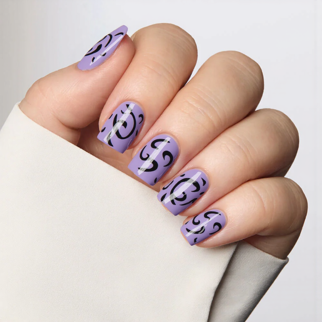 Short square nails in a lilac base, each with a hand-painted black swirl for a bold contrast.