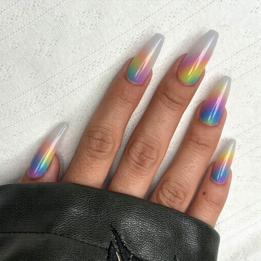 Long stiletto nails in a transparent base, each with a rainbow-colored French tip for a fun statement.