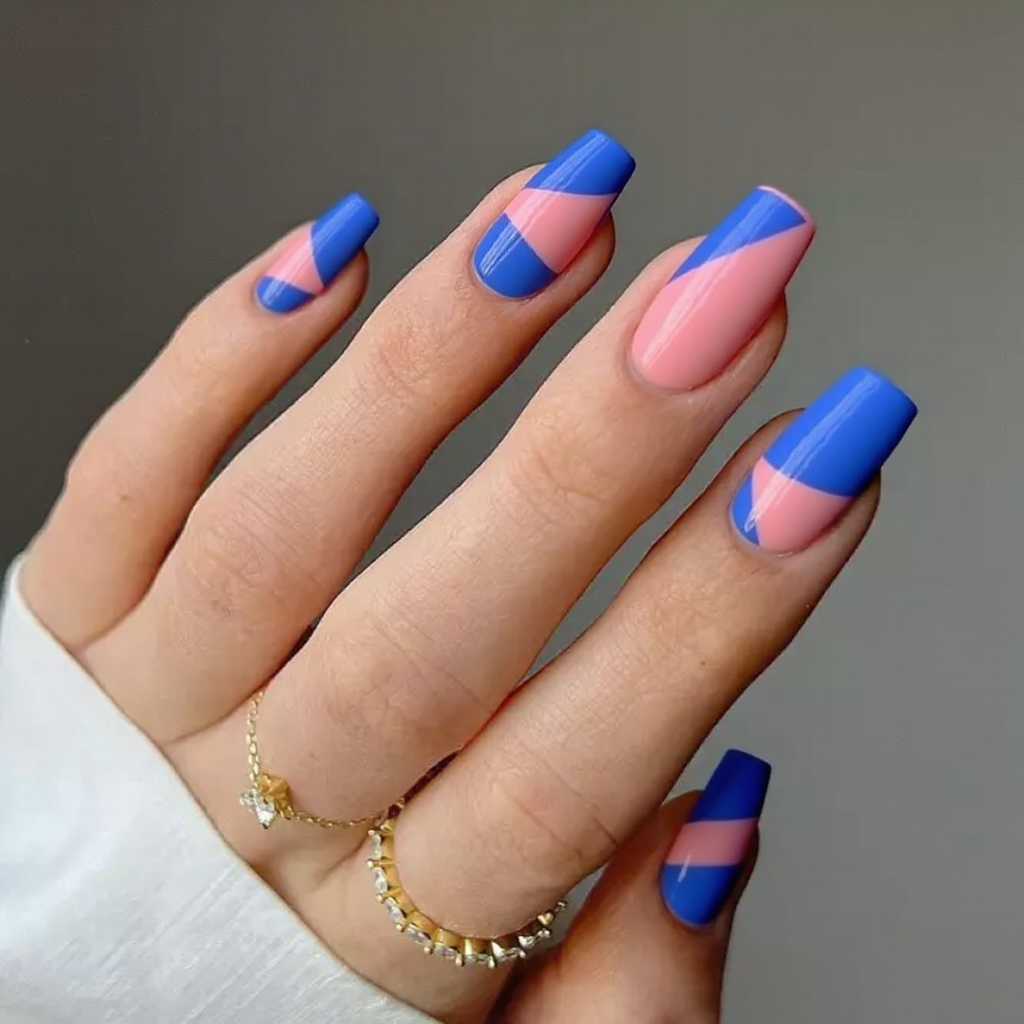 Medium stiletto nails with a geometric color-block nail art design, using bold blues and pinks.