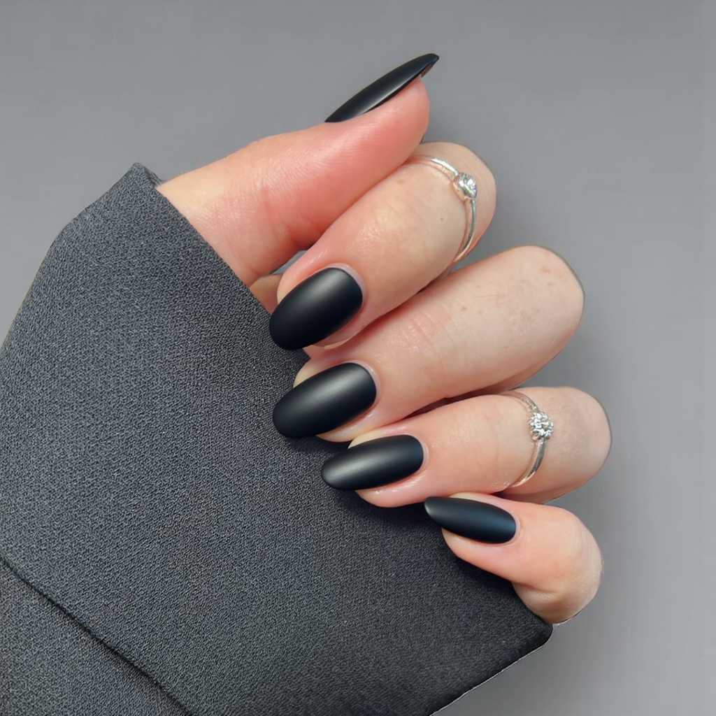 Short almond nails in matte black with a subtle glossy stripe down the center of each nail.