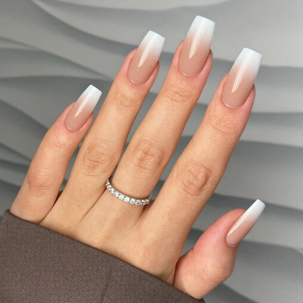 Long almond nails in a frosted French tip—white tips with a translucent shimmer overlay.