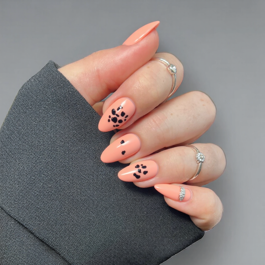 Short almond nails in peach with little paw prints on a couple of nails for an adorable effect.