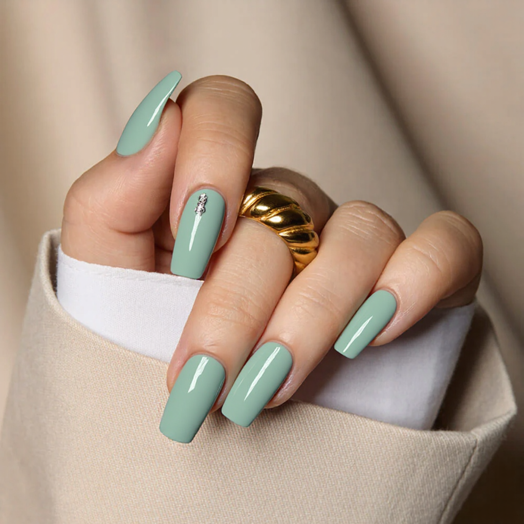 Medium square nails in a subtle mint green, maybe a small silver sticker on the ring finger.