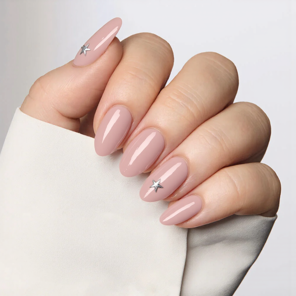 Medium almond nails in a translucent jelly pink, each with a tiny silver star at the tip for a playful look.