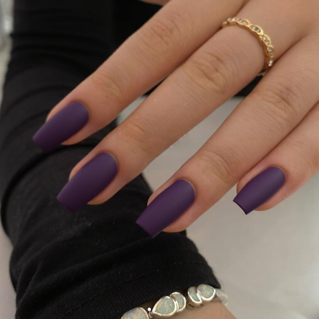 Short stiletto nails in a matte eggplant color, maybe with a glossy French tip for contrast.