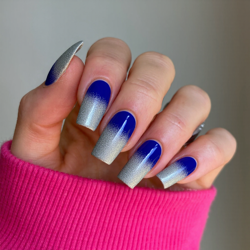 Long square nails in a bold cobalt blue, each with a silver glitter fade at the cuticle.