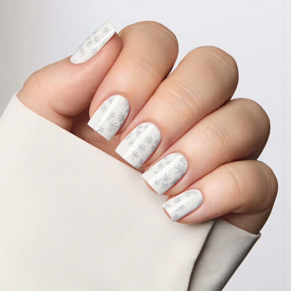 Short square nails with a white base and a barely-there floral pattern sketched in light gray.