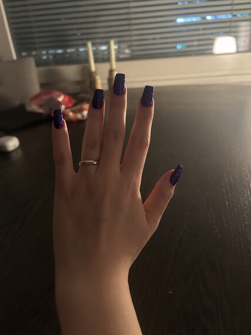 Create a stunning stiletto nail art design inspired by the cosmos. Utilize a captivating gradient of deep dark blue and rich purple tones to evoke the mystery of the universe. Incorporate shimmering glitter to mimic twinkling stars scattered throughout the design. To add an extra layer of intrigue, include tiny accents of a small planet or a crescent moon on one or two nails, enhancing the celestial theme. This long nail design should be bold and eye-catching, perfect for anyone looking to express their love for the night sky.