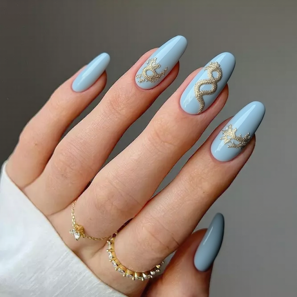 Create an exquisite nail art design perfect for a wedding, featuring elegant stiletto-shaped nails. Use a soft powder blue base as the canvas and incorporate a delicate snake motif in shimmering silver or gold accents. The snake design should elegantly wrap around the nails, symbolizing love and eternity. Add intricate details such as tiny rhinestones or pearls along the snake's body for a luxurious and sophisticated touch. This design should evoke a sense of grace and beauty, making it ideal for the special occasion.
