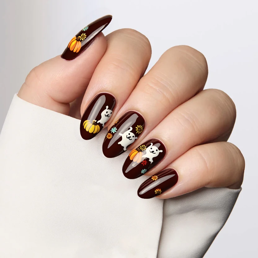 Nails featuring a deep dark brown base, evoking a cozy autumn vibe. On the accent nails, delicate illustrations of playful puppy dog ghosts, each with soft edges in muted pastels, are scattered among charming miniature pumpkins and tiny sunflowers in warm yellows and muted oranges. These whimsical designs are positioned with care to maintain the gentle flow of the almond shape, ensuring they don’t overwhelm the nail. The remaining nails have the same dark brown base, creating a cohesive and elegant look, finished with a glossy shine to enhance the richness of the colors.