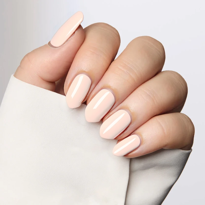 Nails painted in a soft, pastel peach that evokes a light and airy summer feel. The elegant almond shape beautifully highlights the gentle curves of the nails, creating a chic and understated look. The smooth, glossy finish enhances the color's brightness, making it perfect for a summer trip while maintaining a minimalistic and sophisticated aesthetic. Each nail showcases the same refreshing hue, ensuring a harmonious and cohesive appearance.