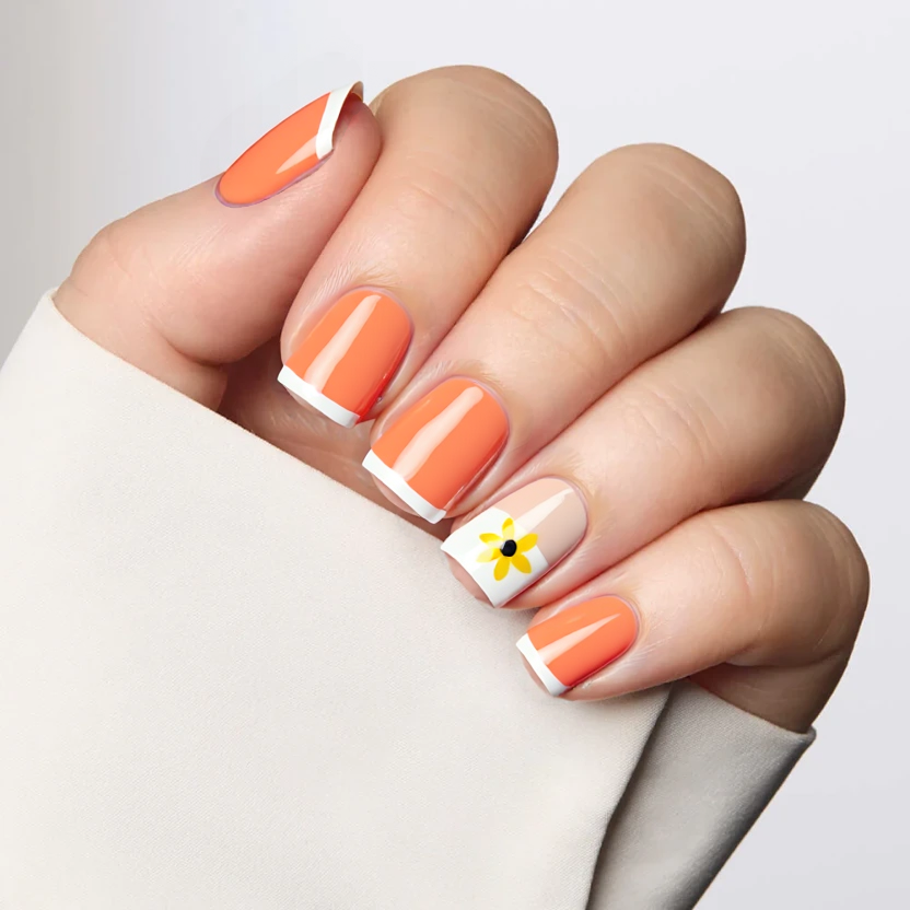 Nails painted in a soft, pastel orange that exudes warmth and vibrancy, perfectly complementing the square shape and short size for a chic yet understated look. On the ring finger, a delicate French tip design features a gentle nude base transitioning into a thin white edge, adorned with a small, hand-painted yellow flower at the center of the nail. This floral accent adds a touch of elegance while maintaining a minimalist aesthetic. The finish across all nails is glossy, enhancing the cheerful orange hue and giving the floral detail a subtle shine without overwhelming the overall design.