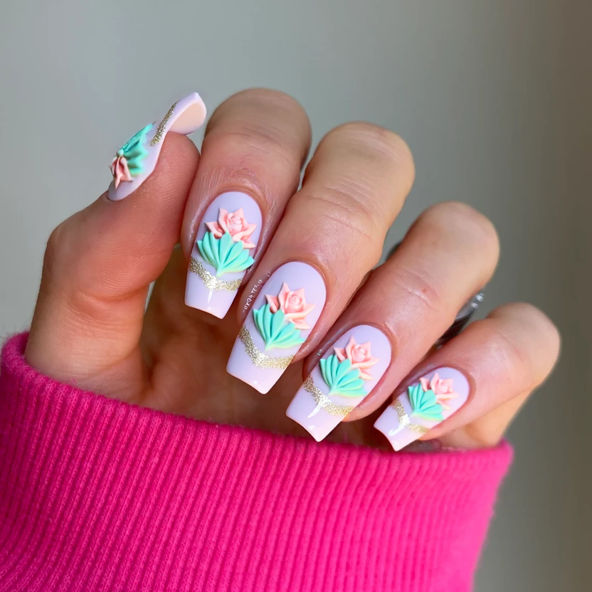 Nails adorned with a serene, glossy base in a soft pastel pink, reminiscent of gentle morning light. The design features a delicate 3D lotus flower at the center of the ring fingers, crafted in a gentle mint hue, surrounded by intricately molded pale pink roses that add a touch of elegance. Subtle waves of shimmering mint accents gracefully flow along the edges of the other nails, creating a soft water-inspired effect. The overall finish is high-shine, enhancing the ethereal quality of the design while perfectly complementing the clean lines of long square nails.