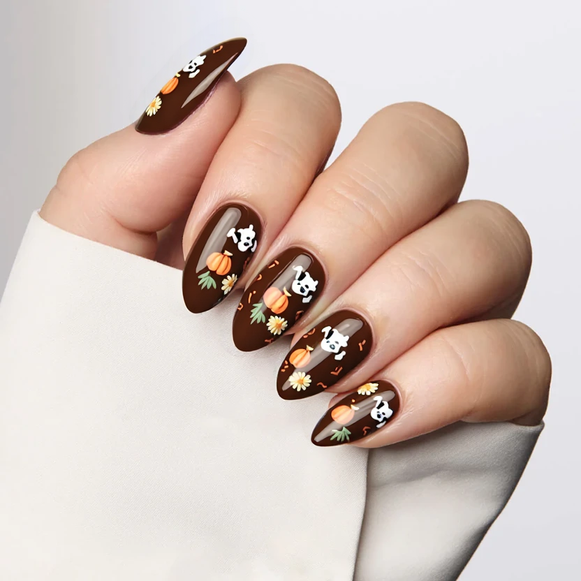 Medium almond-shaped nails feature a dark chocolate brown base color that creates a warm, inviting background. On the index and ring fingers, subtle hand-painted puppy dog ghosts are depicted in soft white, with delicate expressions that add a playful charm. Tiny pumpkins in muted orange tones are scattered throughout the designs, while small sunflowers in pastel yellow with gentle green accents bring a cheerful contrast. The remaining nails are left in the rich brown hue for a cohesive look. A glossy finish enhances the overall elegance of the design, perfect for showcasing the almond shape through its soft curves and gentle details.
