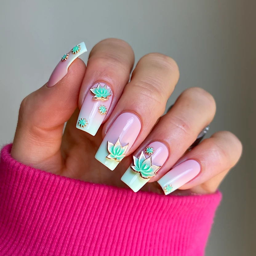 Nails adorned with a soft, pastel pink base color, providing an elegant canvas for intricate detailing. The middle and ring fingers feature delicate 3D elements with shimmering, translucent lotus and rose designs that seem to float above the surface, creating an ethereal effect. These floral motifs are complemented by subtle mint green accents, softly blending around the petals to enhance the water-like theme. The remaining nails are kept simple with just the glossy pink finish, allowing the floral artistry to shine through while maintaining a harmonious balance perfect for the long square shape.